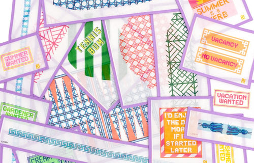 Different types of needlepoint canvases lay on each other displaying their colors and designs.